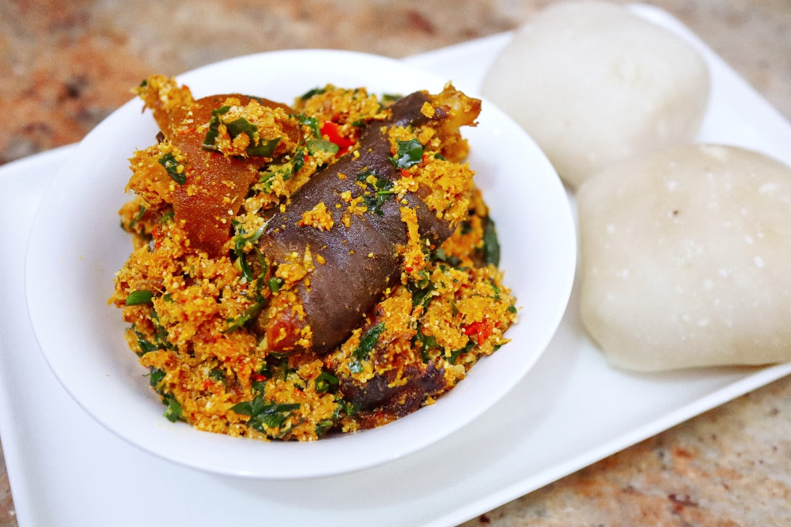 Delicious plate of Egusi soup served with a side of swallow, a popular Nigerian dish enjoyed by many.