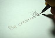 Close-up of handwritten 'Be creative' with a light bulb sketch on paper. What is creative writing? 5 forms of creative writing.